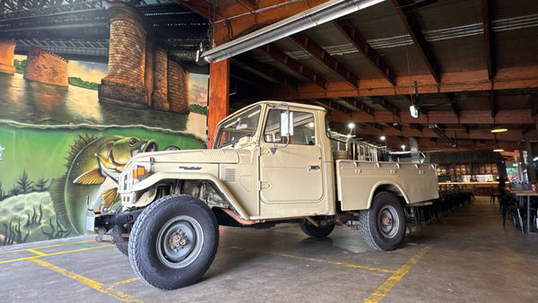 Vintage truck inside a building with a mural on the wall